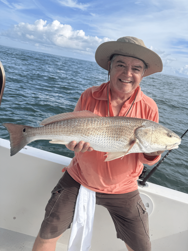 Beast Coast Fishing Charters Man holding red drum fish in New Smyrna Beach
